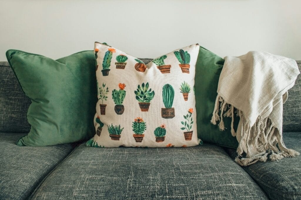 Colorful upcycled fabric cushion with a patchwork design, offering a unique and eco-friendly addition to home decor.